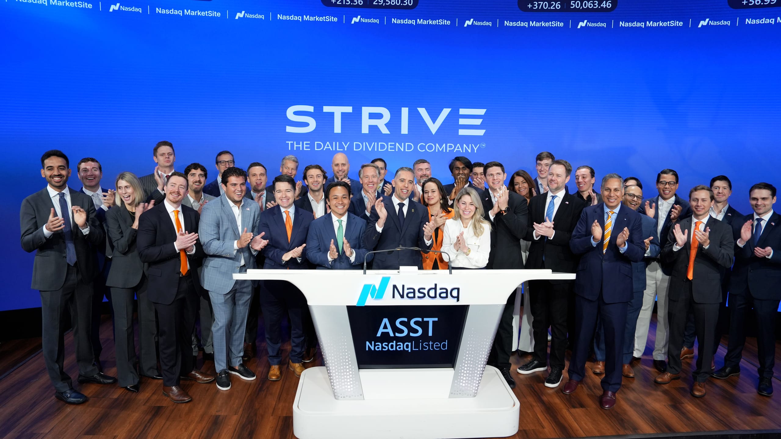 The Strive team at the Nasdaq MarketSite podium for the ASST listing, beneath the STRIVE — The Daily Dividend Company signage, May 2026.